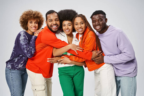 cheerful african american people in colorful casual wear having fun together on grey background