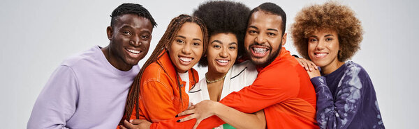 cheerful african american people in colorful casual wear having fun together on grey, banner