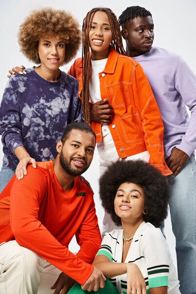 happy african american friends in casual wear spending time together on grey background, Juneteenth