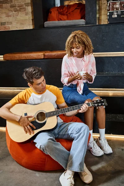 Joven Tocando Guitarra Para Complacer Novia Afroamericana Con Taza Café — Foto de Stock