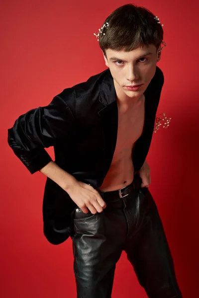 stock image cool young man in stylish outfit with flowers in hair and pocket of velvet blazer looking at camera