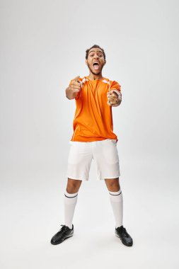 Spor giyimli neşeli Afro-Amerikan sporcu adam aktif olarak işaret ediyor, online bahis oynuyor.