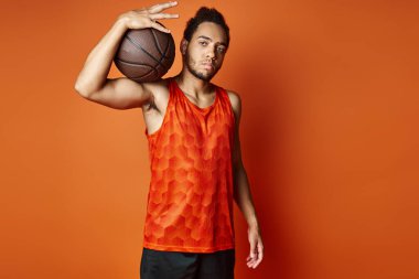 Spor giysili, neşeli Afro-Amerikan adam kollarıyla kameraya neşe içinde gülümsüyor.
