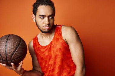 Spor giysili, neşeli Afro-Amerikan adam kollarıyla kameraya neşe içinde gülümsüyor.