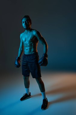 Spor giysili, neşeli Afro-Amerikan adam kollarıyla kameraya neşe içinde gülümsüyor.