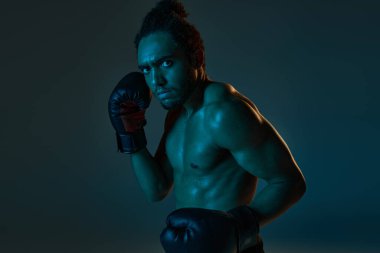 Spor giysili, neşeli Afro-Amerikan adam kollarıyla kameraya neşe içinde gülümsüyor.