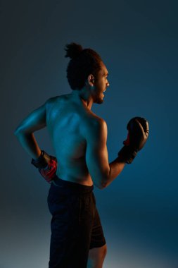 Spor giysili, neşeli Afro-Amerikan adam kollarıyla kameraya neşe içinde gülümsüyor.