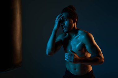 Spor giysili, neşeli Afro-Amerikan adam kollarıyla kameraya neşe içinde gülümsüyor.