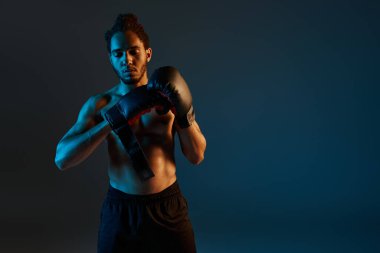 Spor giysili, neşeli Afro-Amerikan adam kollarıyla kameraya neşe içinde gülümsüyor.