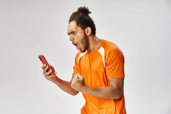 shocked emotional african american man in sportwear looking at his smartphone, online betting