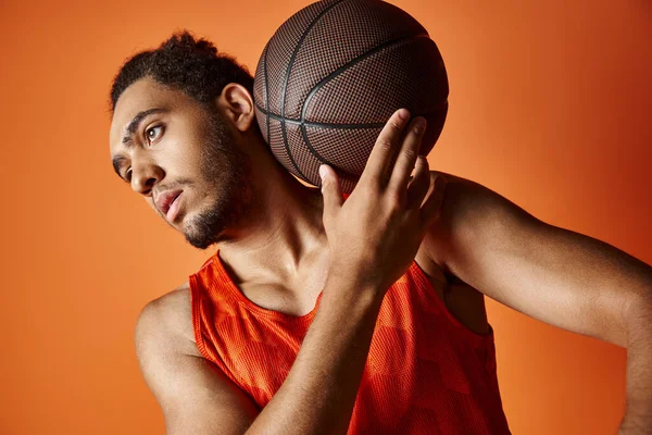 Spor giysili, neşeli Afro-Amerikan adam kollarıyla kameraya neşe içinde gülümsüyor.