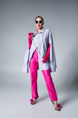 Pembe deri pantolonlu, şık esmer kadın ve kolye takan gözlüklü kadın.