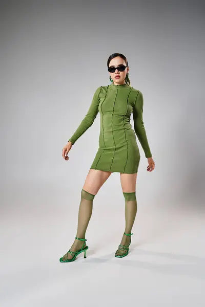 Ładna Kobieta Zielonej Mini Sukience Podkolanówkach Czarnym Okularze Szarym Tle — Zdjęcie stockowe
