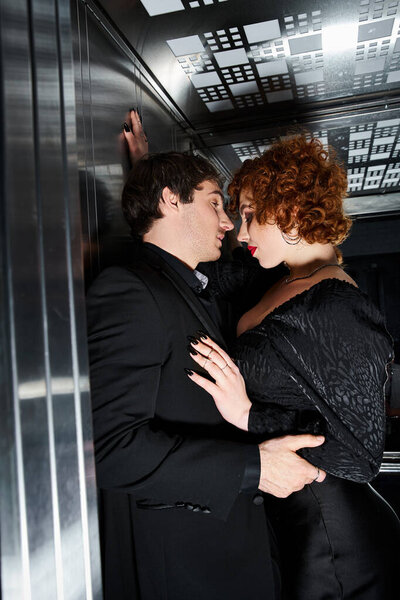 tempting loving boyfriend and girlfriend in elegant black attires hugging in elevator, sexy couple