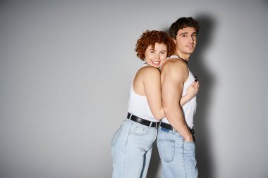 Sevimli, çekici bir çift, rahat kot pantolonlar içinde. Sıcak bir şekilde sarılıyorlar ve kameraya gülümsüyorlar. Seksi bir çift.