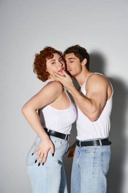 Sevgi dolu erkek arkadaşı ona sarılırken güzel bir kadın kameraya bakıyor. Seksi bir çift.