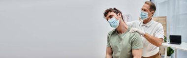Maskeli çekici, olgun bir doktor hastasının hastane koğuşunda iyileşmesine yardım ediyor.