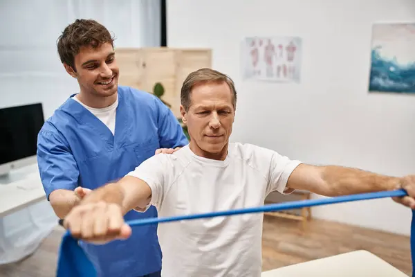 Joyous Attractive Doctor Blue Robe Helping His Mature Patient Use — Stock Photo, Image
