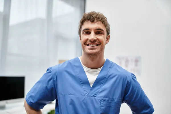 Mavi Üniformalı Hastane Koğuşunda Poz Veren Kameraya Gülümseyen Neşeli Yakışıklı — Stok fotoğraf