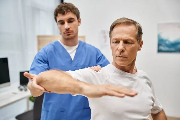 Good Looking Dedicated Doctor Blue Robe Helping His Patient Rehabilitate — Stock Photo, Image