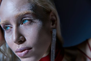 Aksesuarlı, parlak yüzlü, poz veren ve başka yöne bakan genç bir kadını cezbetmeye çalış.