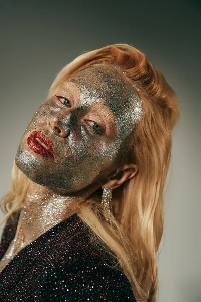 stock image alluring young woman with green eyes and glitter all over body and face posing on grey backdrop