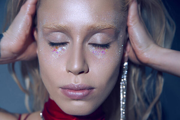 красивая женщина модель с аксессуарами и маркером сбор волос и позирование с закрытыми глазами