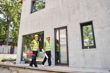 Güvenlik miğferli yazlık inşaatçıları dışarıda çalışan alet çantası seviyesine ve planına sahip.