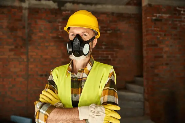 stock image handsome cottage builder with dust mask in safety helmet with arms crossed looking at camera