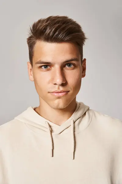 stock image portrait of attractive young man with brown hair and grey eyes against light background