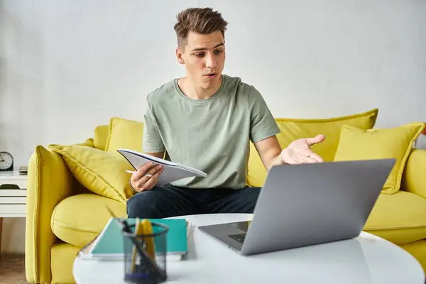 Verwarde Jonge Student Gele Bank Thuis Doet Cursuswerk Notities Laptop — Stockfoto
