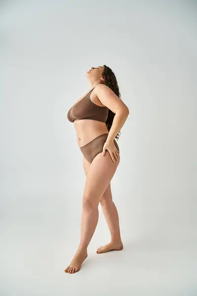 身材迷人的女人 身穿内裤 双手放在臀上 头对背 灰色背景 — 图库照片