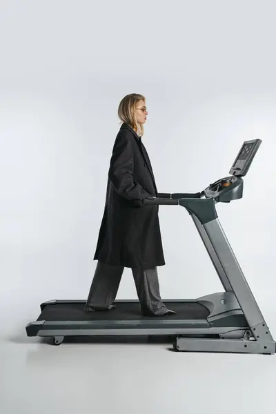 Attractive Sophisticated Woman Fashionable Black Coat Posing Treadmill Gray Background — Stock Photo, Image