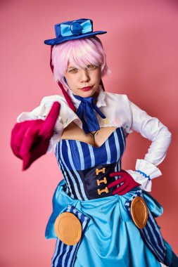 Pembe arka planda mavi şapkalı canlı elbiseli çekici bayan Cosplayer.