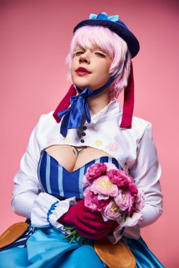 Parlak animasyon kostümlü sevimli bayan Cosplayer pembe çiçekler tutuyor ve kameraya bakıyor.