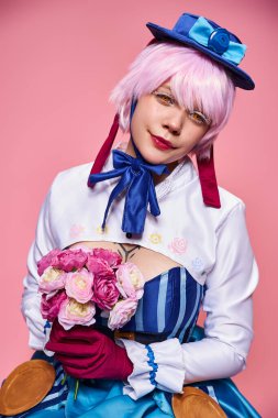 Parlak animasyon kostümlü sevimli bayan Cosplayer pembe çiçekler tutuyor ve kameraya bakıyor.
