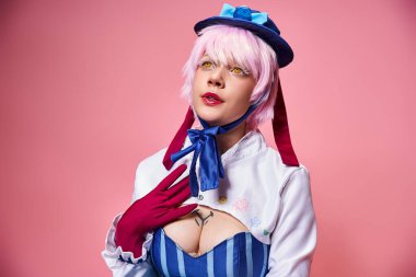 Çekici, modaya uygun bir kadın sevimli bir anime karakteri canlandırıyor ve pembe arka plana bakıyor.