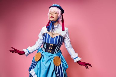 Mavi şapkalı, parlak elbiseli, pembe arka planda kameraya bakan çekici bir bayan Cosplayer.