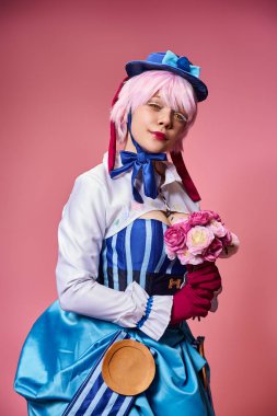 Canlı kostümlü, elinde pembe çiçekler olan ve kameraya bakan sevimli bayan Cosplayer.
