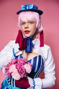 Canlı kostümlü, elinde pembe çiçekler olan ve kameraya bakan sevimli bayan Cosplayer.
