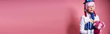 Pembe çiçekli canlı kostümlü güzel bayan Cosplayer ve kameraya bakıyor.