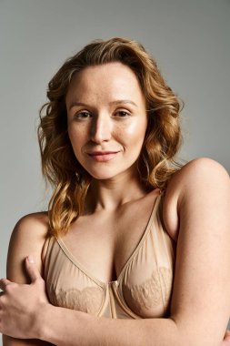 Doğal bir güzellik, kendine güven ve cazibe saçan bir sütyenin içinde büyüleyici bir poz verir..