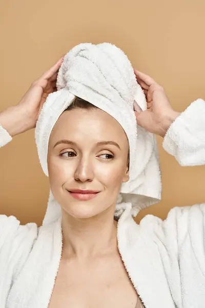 stock image A woman with a towel wrapped around her head, exuding elegance and tranquility.