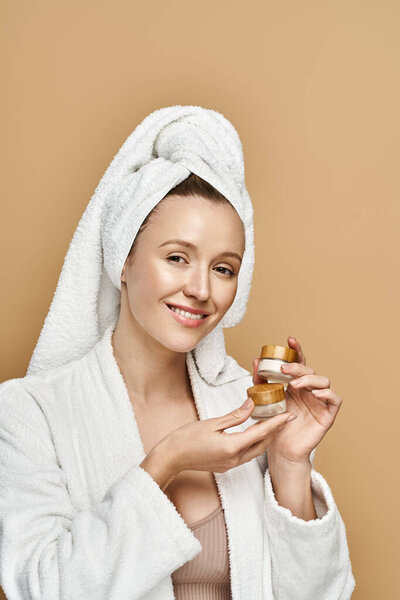 Изящная женщина в элегантном белом халате деликатно держит крем.