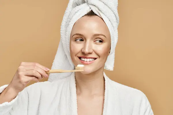 彼女の頭にタオルが付いている魅力的な女性は毎日の朝のルーチンで彼女の歯を磨いています — ストック写真