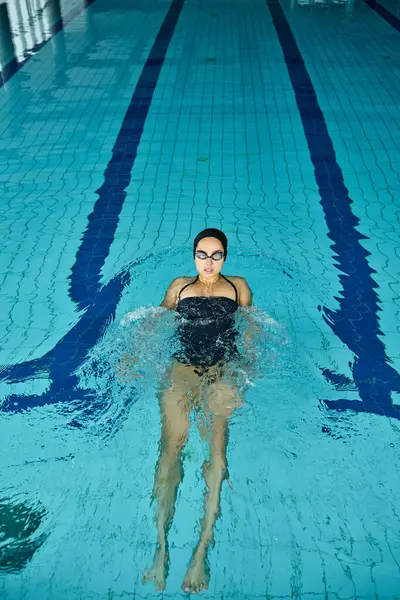 Kobieta Kostiumie Kąpielowym Czepku Wdziękiem Pływa Krytym Basenie — Zdjęcie stockowe