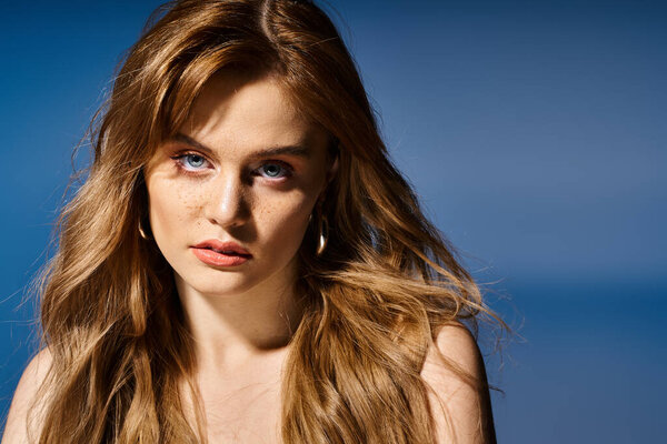 Красота портрет сексуальной женщины с голубыми глазами, глядя на камеру на синем фоне