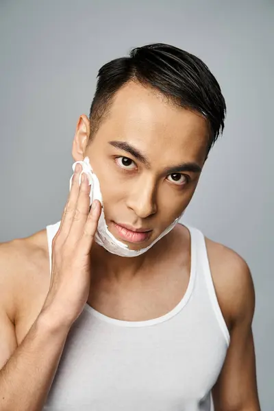 Yüzünde Tıraş Köpüğü Olan Yakışıklı Asyalı Adam Gri Bir Stüdyoda — Stok fotoğraf