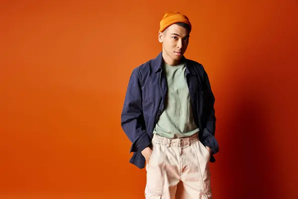 Ung Stilig Asiatisk Man Står Tryggt Framför Pulserande Orange Vägg — Stockfoto