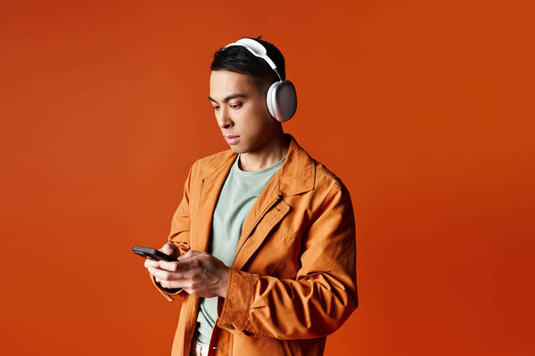 A woman wearing headphones is engrossed in her cell phone, creating a scene of modern connectivity and immersion.